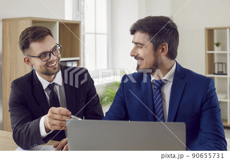 Happy smiling insurance agent or loan advisor meeting with a client in his office 90655731