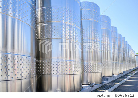 Wine steel tanks, equipment of contemporary winemaker factory.  Barrels for wine storage. Equipment for the fermentation, distillation of alcohol. Preparation workshop for pure alcohols. 90656512