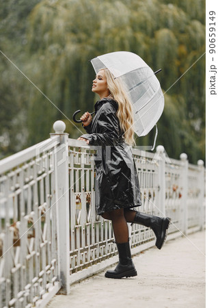 Girl walks. Woman in a black coat. Blonde with a umbrella. Girl walks. Woman in a black coat. Blonde with a umbrella. 90659149