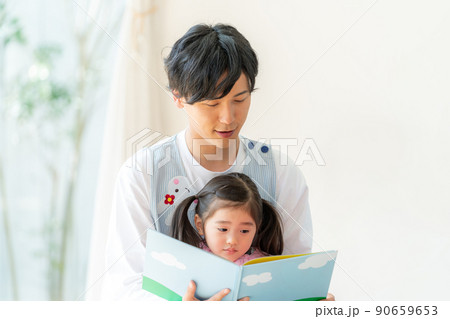 絵本を読む保育士と子供 90659653