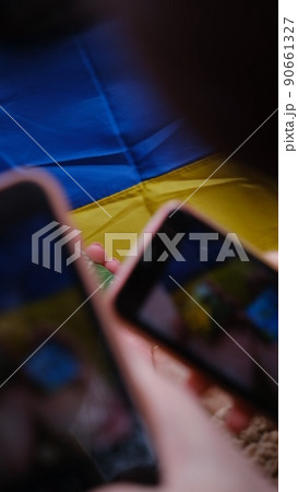 The national flag of Ukraine as a background. Girls, womens with phone in the hands peace in Ukraine, no war, free country, peace in Ukraine The national flag of Ukraine as a background. Girls, womens with phone in the hands peace in Ukraine, no war, free country, peace in Ukraine 90661327