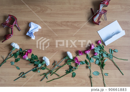crumpled paper of letter and scattered flowerson the floor. Broken relationships in bad Valentine's day. concept. 90661883