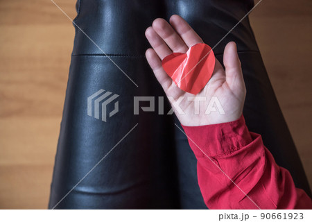 woman with crumpled paper heart in the hand sitting on the floor.  Broken relationships in bad Valentine's day. concept. Top view 90661923