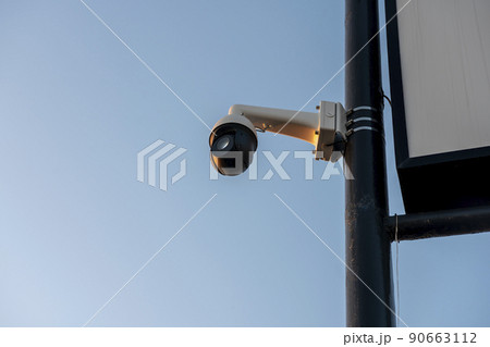 CCTV camera mounted on a tall black pole. Surveillance camera with all-round view. 90663112