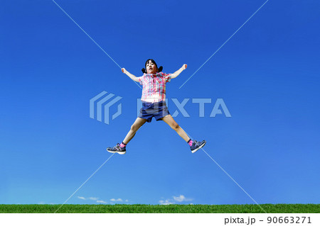 青空を背景に手足を広げジャンプする幼い女の子1人 青空を背景に手足を広げジャンプする幼い女の子1人 90663271