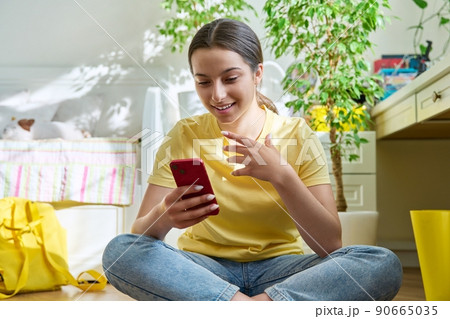 Teenage female using smart phone for conference chat video call 90665035