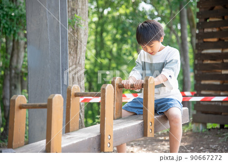 木製シーソーで遊んでいる小学生の男の子 90667272