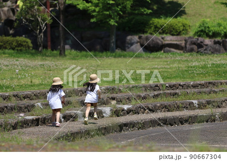 埼玉県鳩山町に在る新緑が爽やかな農村公園内の石段を楽しそうに元気に走って遊ぶ麦わら帽子の幼い姉妹 埼玉県鳩山町に在る新緑が爽やかな農村公園内の石段を楽しそうに元気に走って遊ぶ麦わら帽子の幼い姉妹 90667304