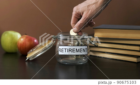 Hand of Man Puts Coin into a Glass with Retirement Savings. Economic Crisis and Financial Difficulties Concept Hand of Man Puts Coin into a Glass with Retirement Savings. Economic Crisis and Financial Difficulties Concept 90675103