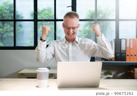 Businessman feeling euphoric celebrating online win success achievement result 90675262