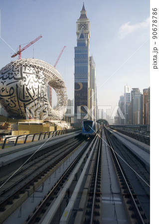 DUBAI, UNITED ARAB EMIRATES - JUN 19, 2019: Metro Dubai train with city skyline behind arriving in station at Sheikh Zayed road DUBAI, UNITED ARAB EMIRATES - JUN 19, 2019: Metro Dubai train with city skyline behind arriving in station at Sheikh Zayed road 90678786