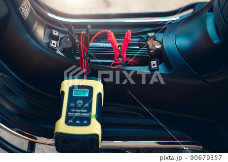 Charging battery and repair in motorcycle for start by portable trickle charger and clamp. 90679357