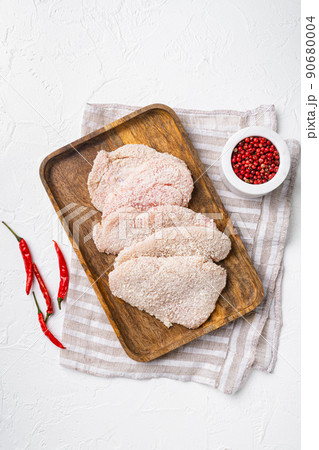 Raw schnitzel chicken meat set, on white stone table background, top view flat lay Raw schnitzel chicken meat set, on white stone table background, top view flat lay 90680004