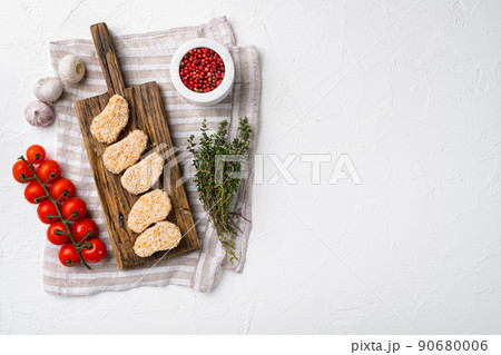 Homemade Raw Breaded Chicken Nuggets set, on white stone table background, top view flat lay, with copy space for text Homemade Raw Breaded Chicken Nuggets set, on white stone table background, top view flat lay, with copy space for text 90680006