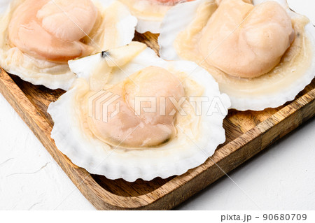 Fresh scallops for a baked recipe, on white stone table background Fresh scallops for a baked recipe, on white stone table background 90680709