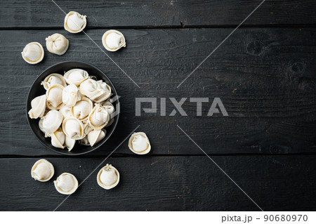 Frozen tortellini in black bowl, on black wooden table background , top view flat lay , with copyspace  and space for text 90680970