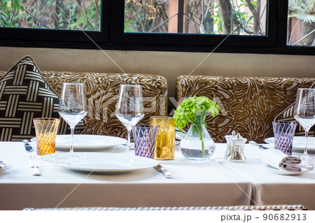 モロッコの街マラケッシュのレストラン　四葉のクローバーが飾られたテーブルとエキゾチックな柄のイス 90682913