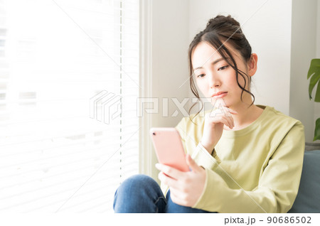 窓際でスマホを操作する女性 窓際でスマホを操作する女性 90686502