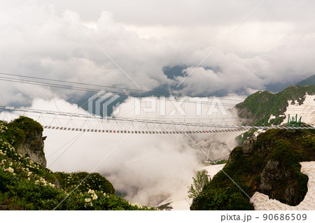 Rope bridge in Sochi mountains against the backdrop of clouds in Rosa Khutor. 90686509