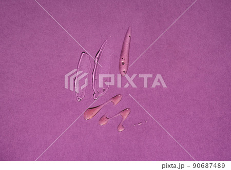 Smears of transparent liquid cosmetics on a purple background 90687489