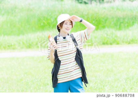 ウォーターボトルを持って公園を散歩する女性 ウォーターボトルを持って公園を散歩する女性 90688708