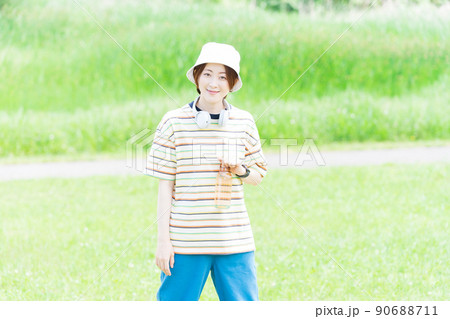 ウォーターボトルを持って公園を散歩する女性 90688711