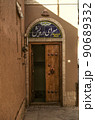 Entrance door on the corner of one of the ancient streets of the old adobe city of Yazd 90689332