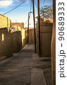 The old city of Yazd streets view in with adobe houses and oblique shadows on the walls of the houses against the blue sky. 90689333
