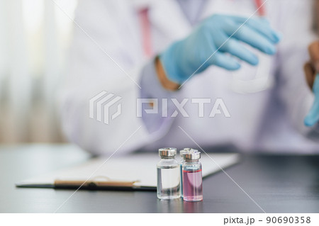 Close up holding a bottle of medicine or vaccine. Concept of medicine and disease prevention. Close up holding a bottle of medicine or vaccine. Concept of medicine and disease prevention. 90690358