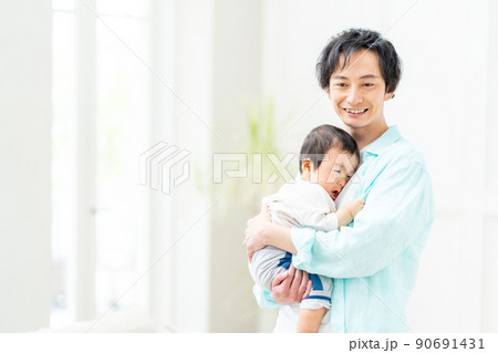 泣いてる赤ちゃんを抱っこしてあやす男性。 泣いてる赤ちゃんを抱っこしてあやす男性。 90691431