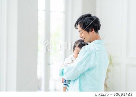 泣いてる赤ちゃんを抱っこしてあやす男性。 泣いてる赤ちゃんを抱っこしてあやす男性。 90691432