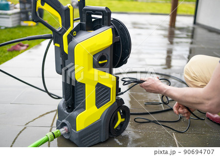 Pressure washer cleaning machine on wet concrete floor near the house build, cleaning terrace with a power washer Pressure washer cleaning machine on wet concrete floor near the house build, cleaning terrace with a power washer 90694707