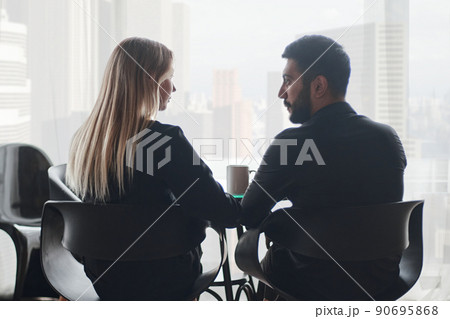 businessman and businesswoman talking sitting at a coffee table. 90695868