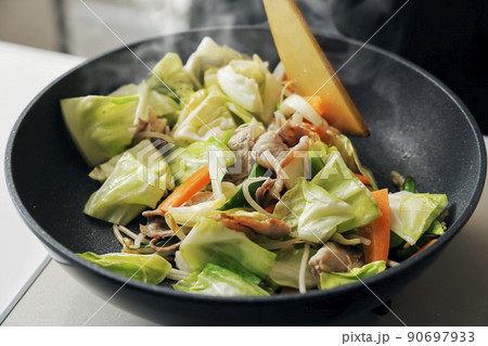 フライパンで調理している豚肉の野菜炒め 90697933