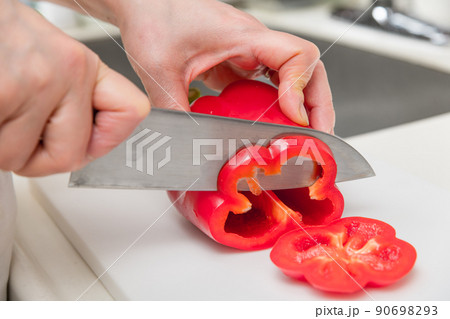 【パプリカ赤色を三徳包丁で輪切りにする】 90698293