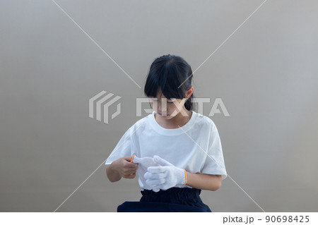 夏の自宅で軍手を着用している小学生の女の子の様子 90698425