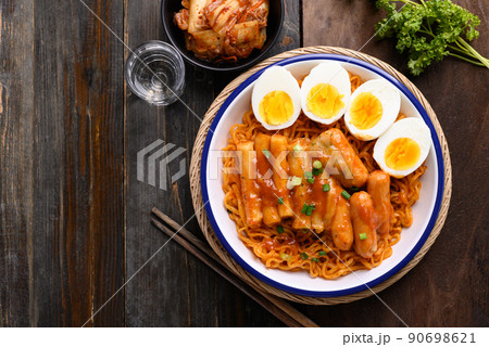 Korean spicy instant noodle with Tteokbokki, sausage and egg on wooden background, Table top view 90698621
