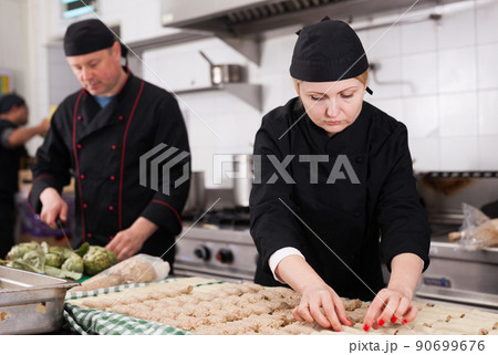 Female cook preparating cannelloni Female cook preparating cannelloni 90699676