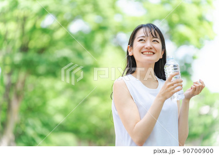 新緑の中で水分補給をする女性 新緑の中で水分補給をする女性 90700900