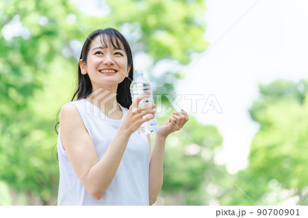新緑の中で水分補給をする女性 新緑の中で水分補給をする女性 90700901