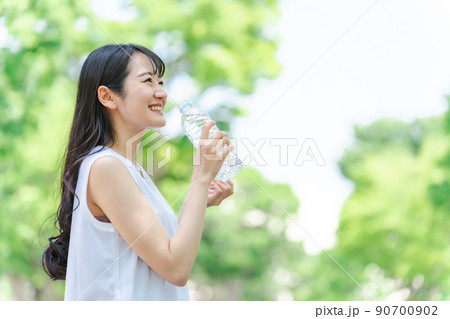 新緑の中で水分補給をする女性(横顔) 新緑の中で水分補給をする女性(横顔) 90700902