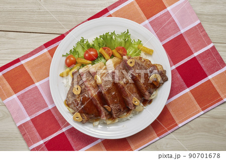 プレートに盛り付けた洋風なステーキ丼 90701678