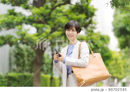 スマホを持つ女性 ビジネス スマホを持つ女性 ビジネス 90702595