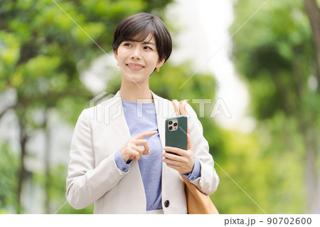 スマホを持つ女性 ビジネス スマホを持つ女性 ビジネス 90702600