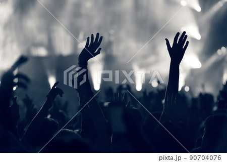 Crowd at a music concert, audience raising hands up, toned 90704076