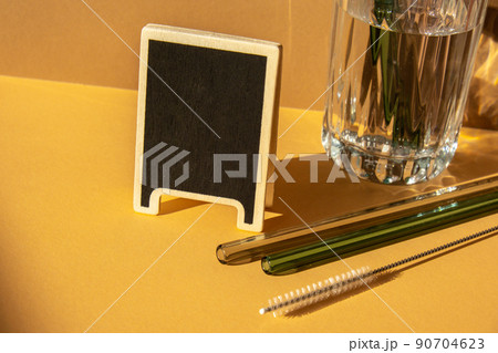 Reusable glass Straws in Glass with water on beige neutral background with label for your text Low-waste lifestyle Eco-Friendly Drinking Straw Set with cleaning brush. Zero waste, plastic free concept Reusable glass Straws in Glass with water on beige neutral background with label for your text Low-waste lifestyle Eco-Friendly Drinking Straw Set with cleaning brush. Zero waste, plastic free concept 90704623