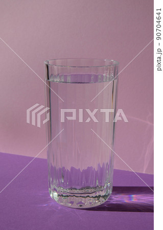 High quality photocreative, diagonal, isometric projection, still life of glass of water on purple violet background. Copy space for text High quality photocreative, diagonal, isometric projection, still life of glass of water on purple violet background. Copy space for text 90704641