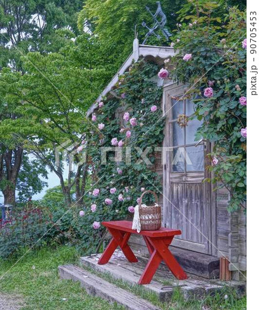北欧風の小屋とローズとベンチの景色　＊縦長長方形構図 90705453