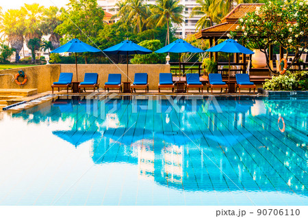 Beautiful umbrella and chair around swimming pool in hotel and resort 90706110
