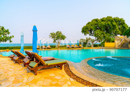 chair pool  or bed pool and umbrella around swimming pool with sea background 90707177